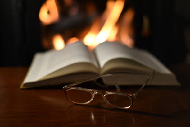 istock Old Reading Glasses On Old Book And Fireplace 934634382