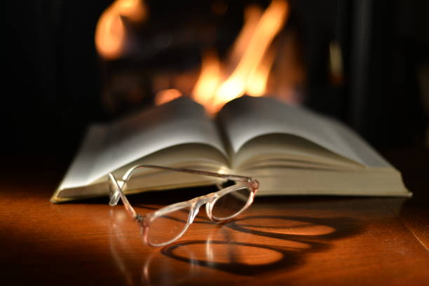 istock Old Reading Glasses On Old Book And Fireplace 934634412