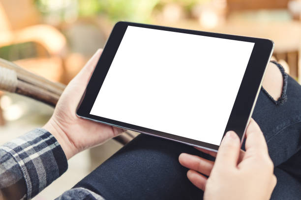 istock Mockup image of a woman holding black tablet pc with blank white screen with  blur background in cafe 934637332