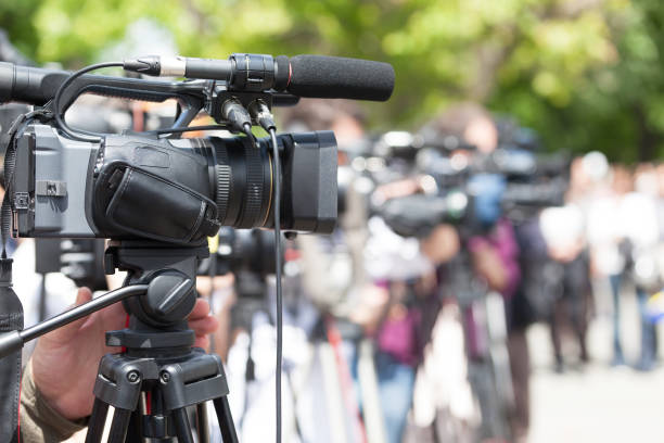 istock News conference. Filming media event with a video camera. 934642544