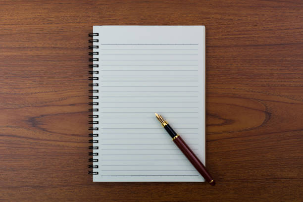 istock Fountain pen or ink pen with notebook paper on wooden working table with copy space, office desk concept. top view. 934643182