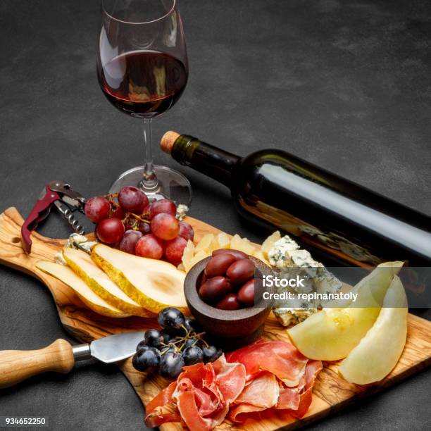 Meat Plate Antipasti Snack Prosciutto Ham Blue Cheese Melon Grapes Olives Stock Photo - Download Image Now