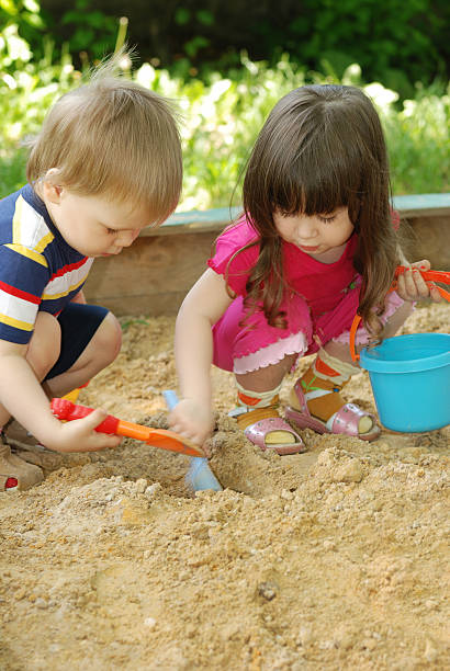 The boy and girl playing to a sandbox stock photo