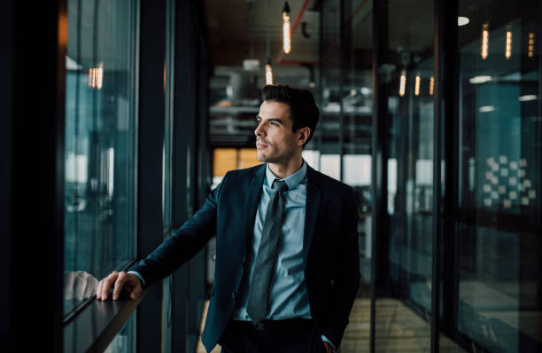 Thoughtful businessman Thoughtful businessman looking through the window rich man stock pictures, royalty-free photos & images