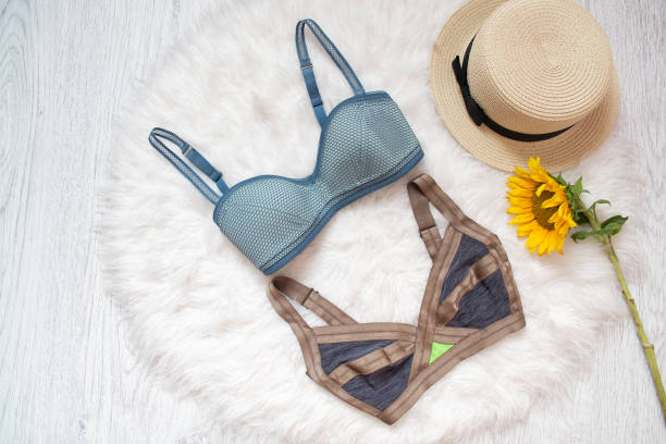 istock Two colored bra, straw hat and sunflower. White fur on the background 934666962