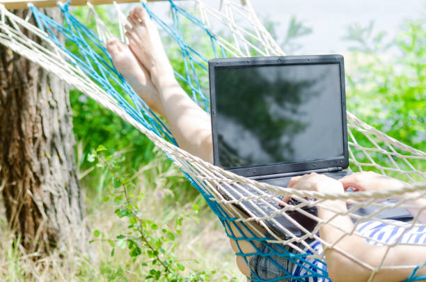 istock Young man in a hammock working on a laptop, concept of work on vacation, freelancing. 934669316