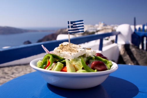 A perfect Greek salad, incorporating olives, green peppers and feta cheese, topped with a Greek flag, in Oia, Santorini