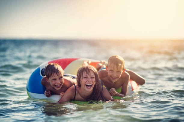 istock Kids playing in sea on swim ring 934670318