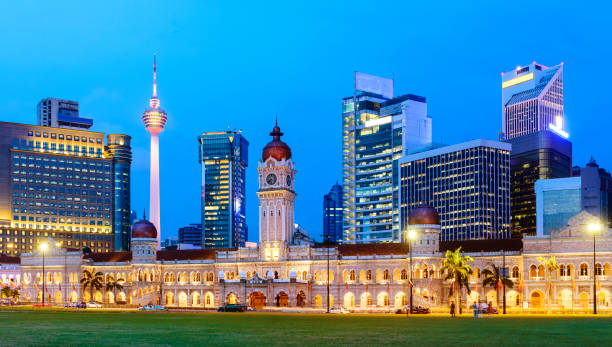 Merdeka Square and the Kuala Lumpur City Skyline Illuminated at Sunset, Malaysia Mix of Twilight and Illuminated Buildings merdeka square stock pictures, royalty-free photos & images