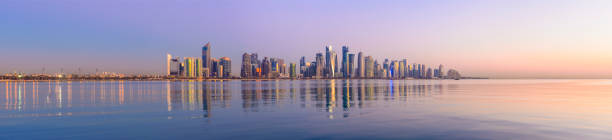 Panoramic View of the Downtown Doha City Skyline at Twilight, Qatar View Across the Corniche Bay with Skyline Reflected in the Water corniche photos stock pictures, royalty-free photos & images