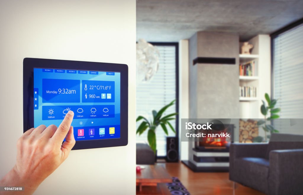 Home automation in living room Person using home automation to control lighting, heating, air conditioning ... etc in modern apartment with fireplace, large windows with blinds, wooden floor and concrete ceiling. Home Automation Stock Photo