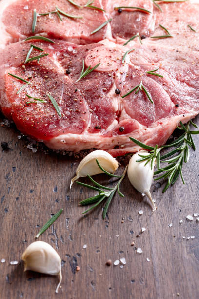 Raw pork with rosemary , salt and pepper.