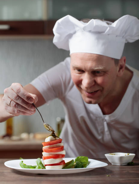 istock Chef prepares a snack with mozzarella and pesto sauce . 934682536