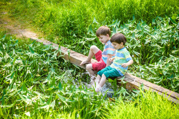 istock Two cute little boys sitting on a wooden bridge 934682798