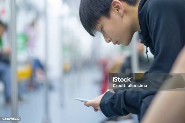 Mrt にスマート フォンを使用してアジアの 10 代の少年 - スマートフォンのストックフォトや画像を多数ご用意 - スマートフォン, 1人, 中国