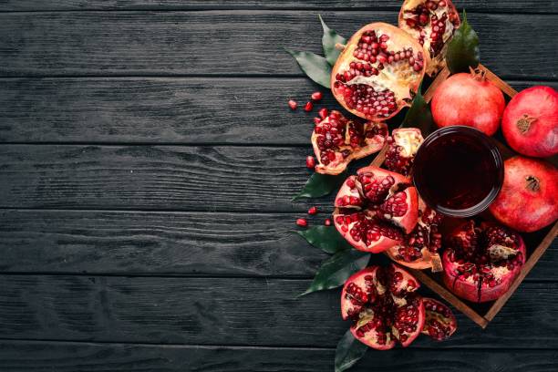 istock Fresh pomegranate juice. Pomegranate. On a black wooden background. Top view. Copy space. 934693926