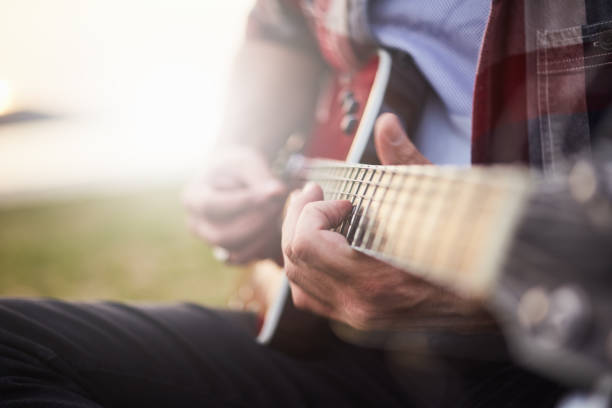 istock man playing guitar outdoors at the beginning of spring 934701918