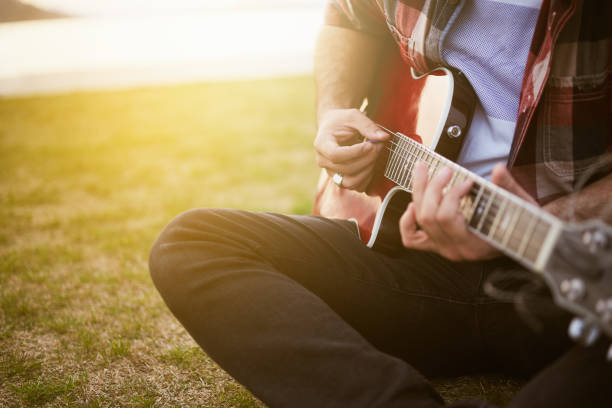 istock man playing guitar outdoors at the beginning of spring 934706634