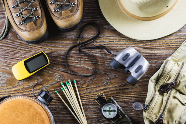 istock Hiking or travel equipment with boots, compass, binoculars, matches on wooden background. Active lifestyle concept. 934706984