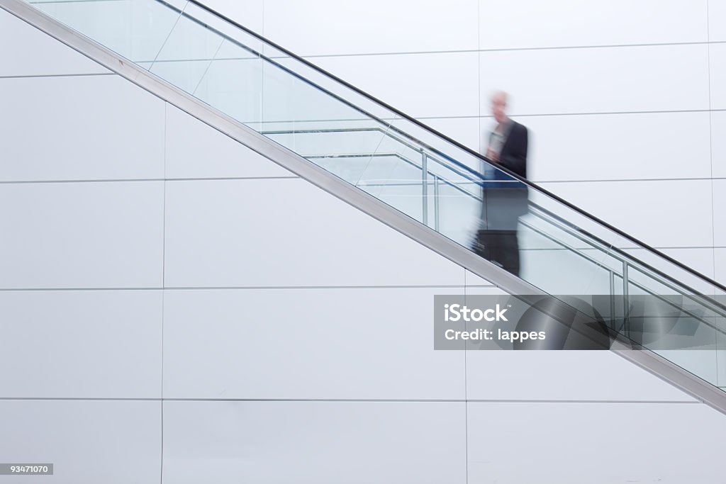 Un hombre de negocios sobre la escalera mecánica - Foto de stock de Escaleras libre de derechos