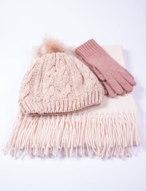 Warm winter knitted clothes - hat, scarf, gloves on a white background. stock photo