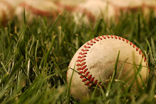 Baseballs sitting on lush green grass Nostalgic baseballs in the grass on a baseball field  old baseball stock pictures, royalty-free photos & images