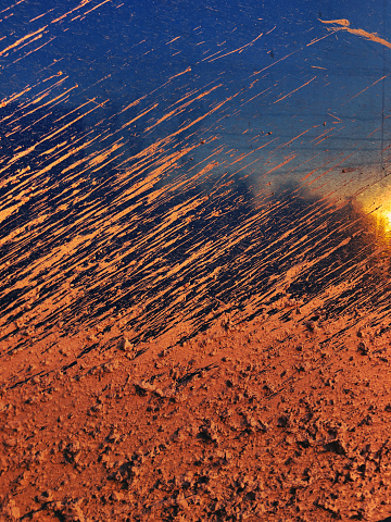 Background image of mud covered vehicle with half dirt and half reflective metal.