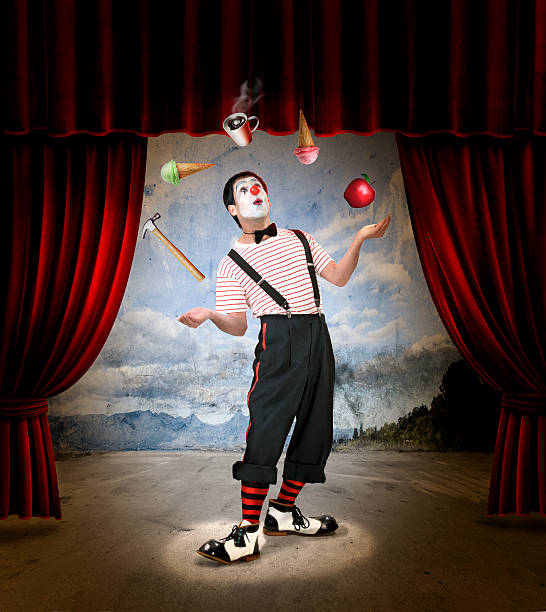 A clown that's juggling ice cream, coffee, Apple, and hammer Clown performing on stage with red curtains circus performer stock pictures, royalty-free photos & images