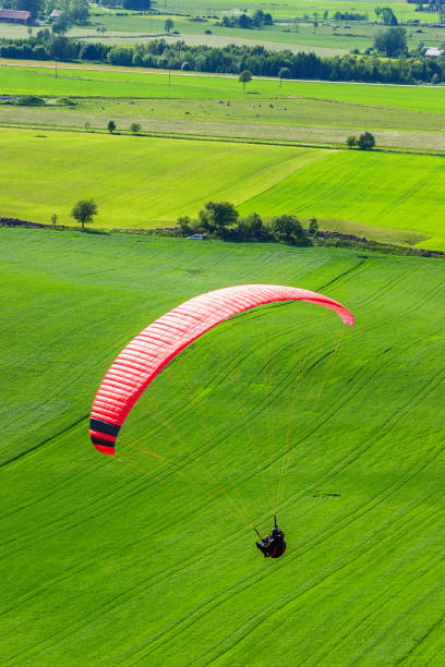 istock Paragliders over green fields in a rural landscape 934773044