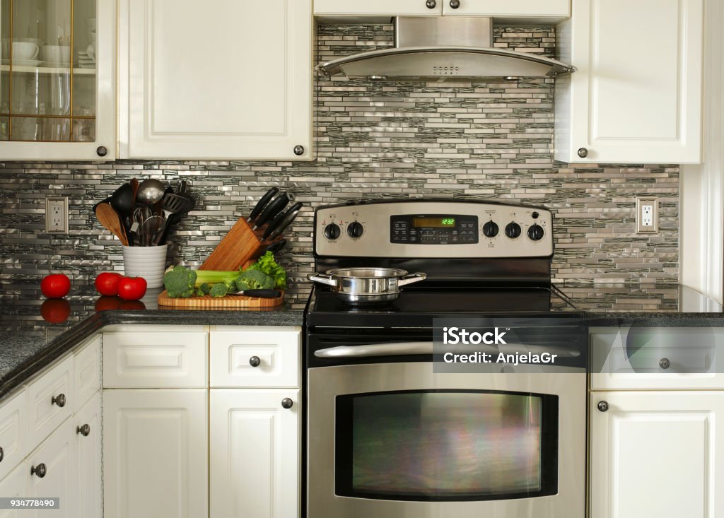 Electric Stainless steel stove, kitchen utensils and vegetables on the cooking table Kitchen Stock Photo
