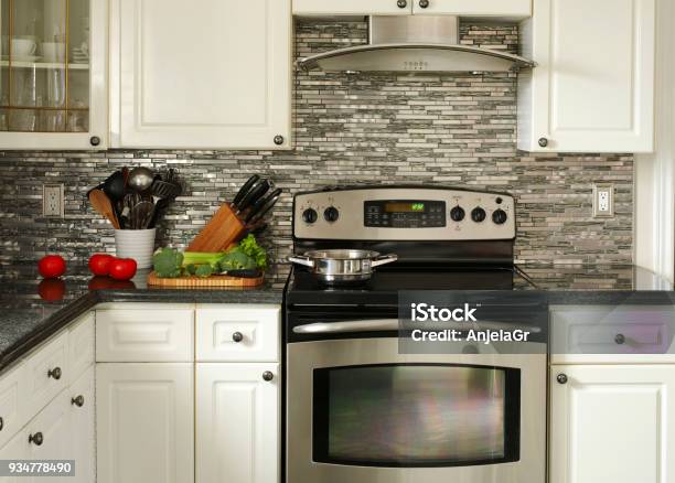 Electric Stainless Steel Stove Kitchen Utensils And Vegetables On The Cooking Table Stock Photo - Download Image Now