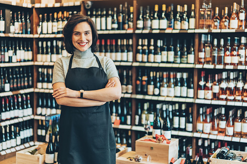 Smiling young female wine shop owner