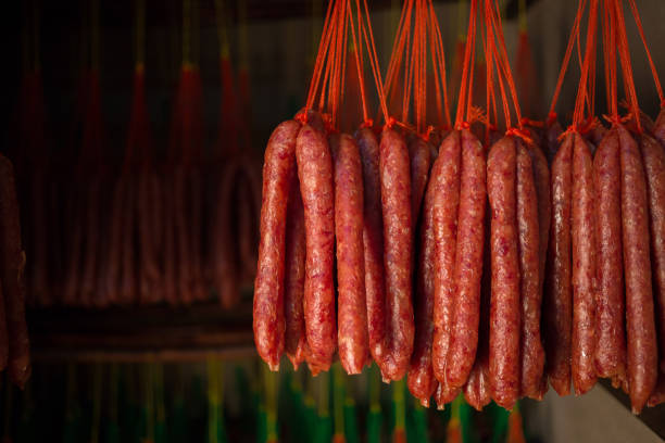 Fresh and dried Chinese sausages hang from racks.