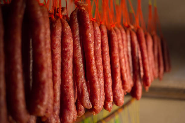 istock Fresh and dried Chinese sausages hang from racks 934782386