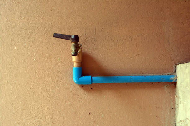 istock old  and rusty faucet with blue water pipe on old orange cement wall 934785376