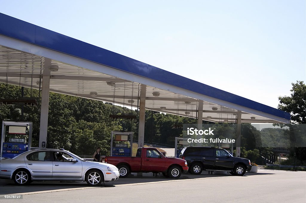 Three cars filling up at a petrol station Sedan, Truck and SUV filling up at gas station. Posted prices legible on pumps. Gas Station Stock Photo