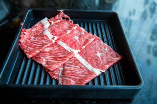 slice beef in black plate, serving for shabu shabu or sukiyaki . image for background, wallpaper ,copy space and menu list.
