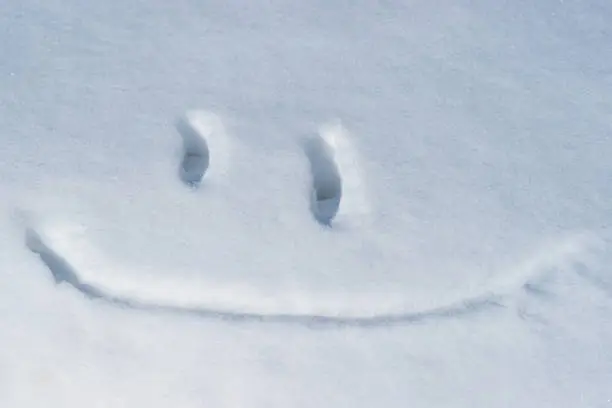 Smiley-face emoji made in a white snow