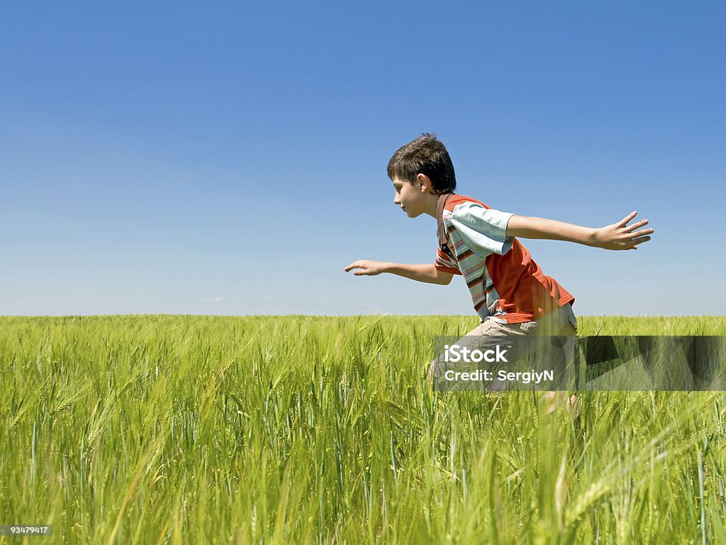 Niño corriendo en el campo - Foto de stock de 10-11 años libre de derechos