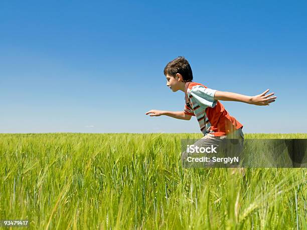 Niño Corriendo En El Campo Foto de stock y más banco de imágenes de 10-11 años - 10-11 años, Aire libre, Azul