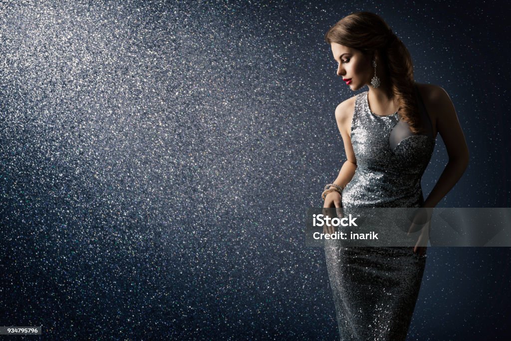 Silver Dress, Fashion Model Posing in Sparkling Sexy Gown, Woman Beauty Portrait over Lighting Sparkles Silver Dress, Fashion Model Posing in Sparkling Sexy Gown, Elegant Woman Beauty Portrait on Lighting Sparkles Background Women Stock Photo