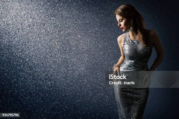 Silver Dress Fashion Model Posing In Sparkling Sexy Gown Woman Beauty Portrait Over Lighting Sparkles Stock Photo - Download Image Now