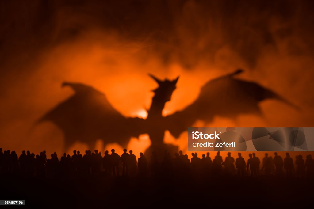 Blurred silhouette of giant monster prepare attack crowd during night. Selective focus. Decoration Blurred silhouette of giant monster prepare attack crowd during night. Selective focus. Dragon Stock Photo