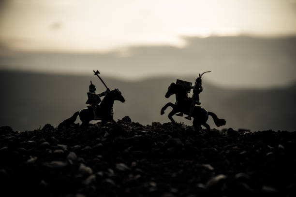 istock Joust between two knights on horseback. Sunset on background. Selective focus 934807280