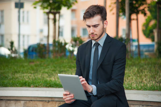 istock young businessman reading in a park 934812676