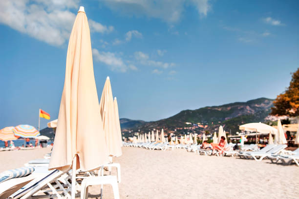 Blurred beach scene with sun loungers and umbrellas.