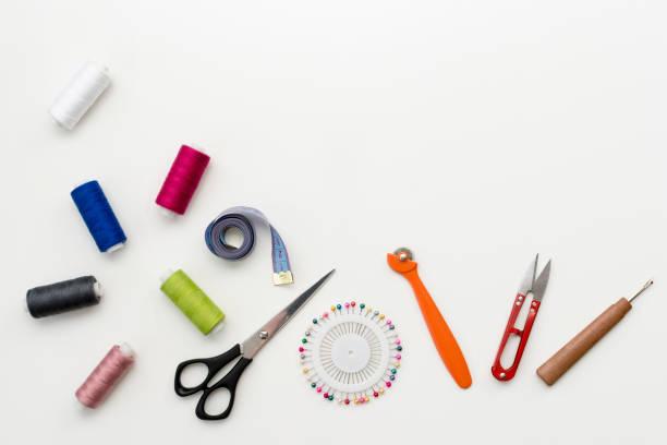 istock Tailor's work desk. Pattern of sewing accessories and tools on white background top view copyspace 934813418
