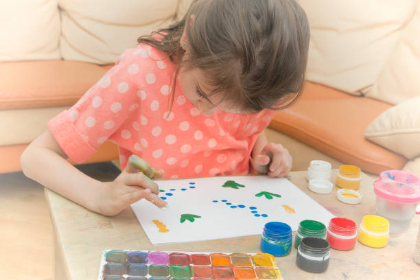 istock The girl paints on paper with her hand 934818086