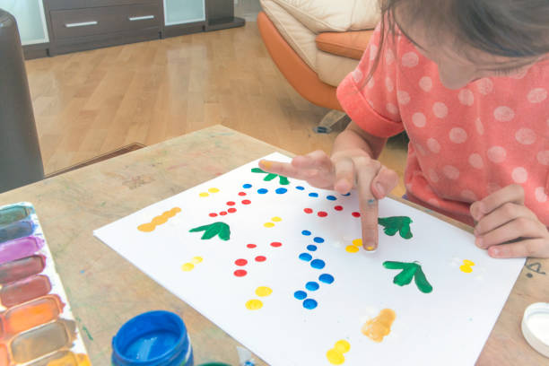 istock The girl paints on paper with her hand 934818100