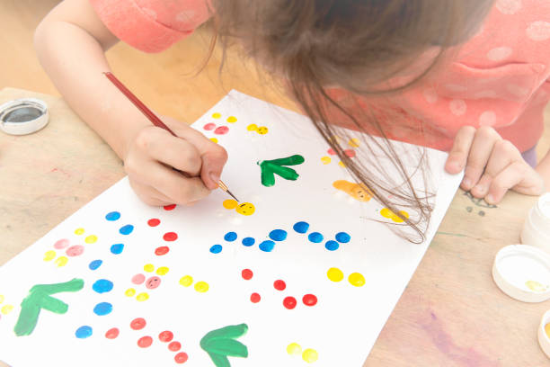 istock The girl paints on paper with her hand 934818210